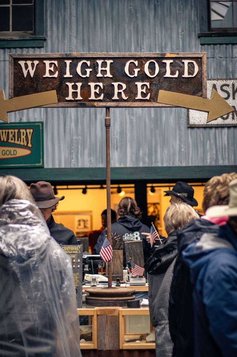 People weighing their gold